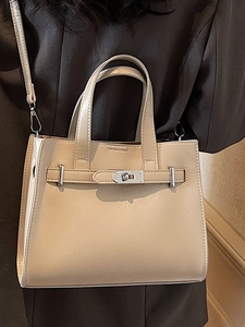 Elegant beige trapezoid handbag with silver hardware shown from a stylish side view angle