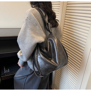 Detailed view of black pleated tote bag showing large capacity and soft PU leather texture