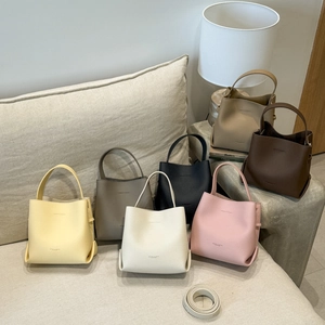 Collection of lychee texture bucket bags in seven colors displayed on a cozy sofa