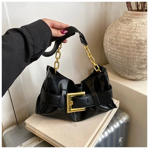 Detail view of a black pleated shoulder bag featuring a large gold buckle and chain strap