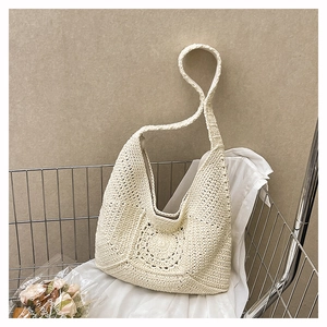 Detail of hollow floral crochet pattern on cream cotton woven shoulder bag