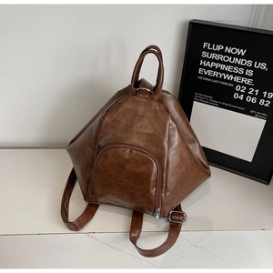 Close-up of brown faux leather vintage backpack with geometric texture and silver hardware