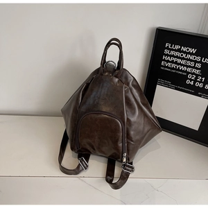 Detailed view of the textured dark brown vintage leather on the pleated tote bag