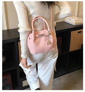 Detailansicht der rosa Litschi Ledertextur und des silbernen Drehverschlusses der Tasche