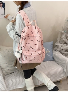 Detail of pink waffle texture backpack with red bow pattern and cute puppy pendant