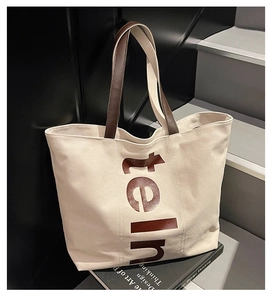 Détail du sac fourre-tout en toile avec anses en cuir marron et imprimé teIn