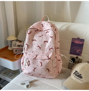 Detailed view of pink school backpack with bow patterns and textured bubble fabric