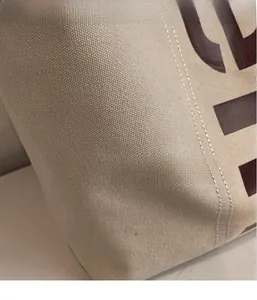 Gros plan sur la toile écrue durable avec coutures de qualité et logo imprimé sur le sac