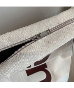 Détail de la fermeture éclair en métal argenté sur un sac cabas en toile épaisse