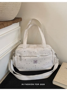 Detail view of white nylon bowling bag with silver star prints and adjustable strap