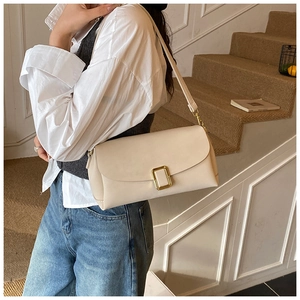 Gros plan du sac à bandoulière carré crème avec fermoir métallique doré minimaliste