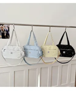 Detailed close-up showing four color variants of star print crossbody bags with zippers