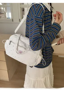 Detail of white multi-pocket star print shoulder bag with stylish pink brand patch