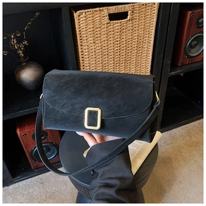 Vue détaillée d'un sac carré en similicuir noir texturé avec une boucle en métal doré