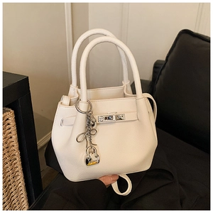 Macro shot of white lychee leather texture and silver buckle on bucket bag