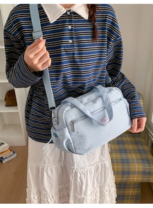 Detail view of light blue star print crossbody bag with adjustable strap and side pockets