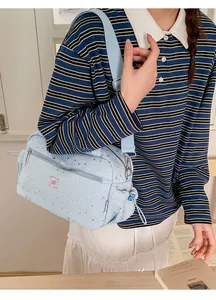Detail of light blue star pattern crossbody bag with adjustable fabric shoulder strap