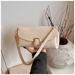 Détail du sac bandoulière crème avec boucle dorée élégante et bandoulière en cuir