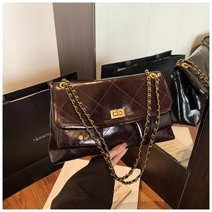 Detail of burgundy diamond quilted leather tote bag with gold chain and turn-lock