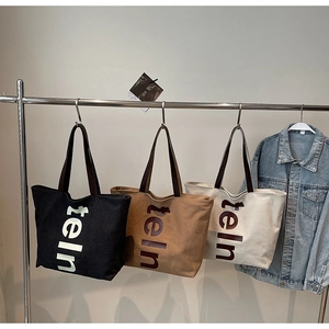 Détail de grands sacs cabas en toile avec lettrage teln en noir et coloris kaki