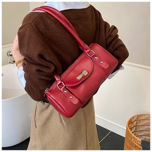 Retro dark red leather baguette bag with metal buckle shown in a lifestyle shoulder view