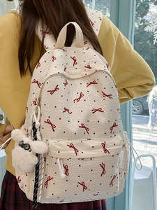 Off-white backpack with red bows and black dots featuring a cute dog pendant