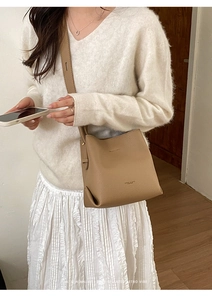 Close-up of tan lychee grain leather bucket bag with ZEKE & BAG logo and shoulder strap