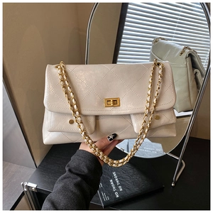 Detail of cream quilted leather shoulder bag featuring gold chain strap and twist-lock