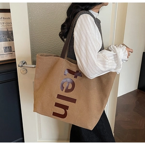 Détail du grand sac cabas en toile avec imprimé de lettres et large bandoulière marron