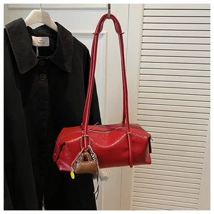 Detail of red Boston bag in glossy patent leather with mini charm and metal hardware