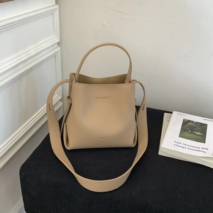 Detail of beige lychee grain leather bucket bag with detachable wide shoulder strap