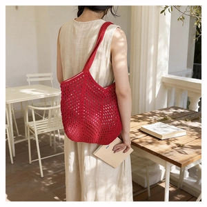 Detail view of the red hollow crochet knit tote bag with a woven mesh texture for summer