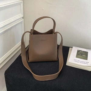 Detail of coffee brown lychee pattern leather bucket bag with top handle and strap