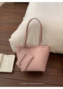 Detail of dusty pink pebbled leather tote bag with matching zippered pouch and book