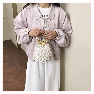 Détail du sac en filet blanc tissé à la main avec poignées rondes en bois