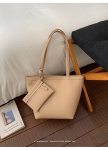 Detail view of beige lychee texture leather tote bag set with knotted strap in a cozy interior