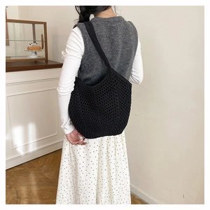 Detailed view of black crochet hobo bag with large mesh hollow weave pattern