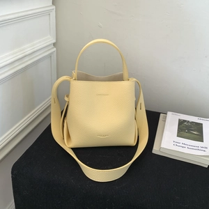 Detail of yellow lychee grain leather bucket bag with wide strap and fashion logo