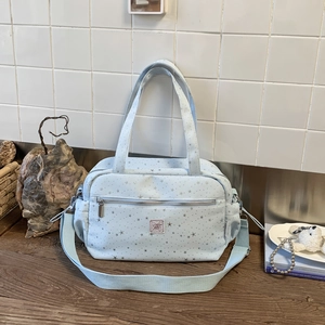 Detailed shot of large light blue star print shoulder bag with adjustable strap and zip pocket