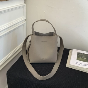 Close-up of litchi grain leather bucket bag with top handle and wide shoulder strap