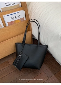 Detail of black pebbled leather tote bag with white stitching and matching coin purse