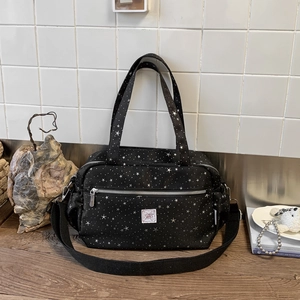 Detail view of large capacity black canvas tote with white star patterns and top handles
