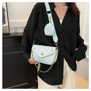 Detail of light blue quilted crossbody bag with gold chain and matching round coin purse