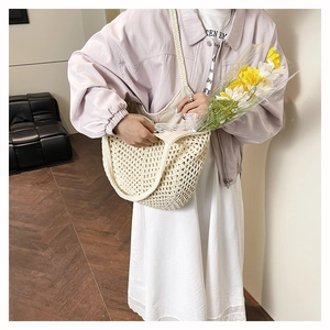 Detailed close-up of a cream hollow-knit tote bag featuring a textured woven fiber pattern