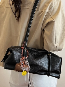 Chic black patent leather rectangular shoulder bag with unique charms and crinkle texture