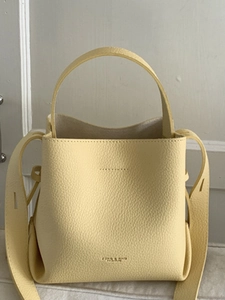 Chic pale yellow bucket bag with lychee texture and integrated handle for daily commute