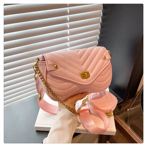 Detail of pink quilted leather shoulder bag with gold chain and matching mini heart pouch