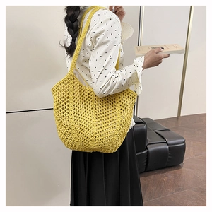 Close-up of bright yellow crochet tote bag with open mesh design and woven handles