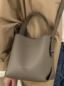 Elegant taupe litchi grain leather bucket bag with top handle and crossbody strap