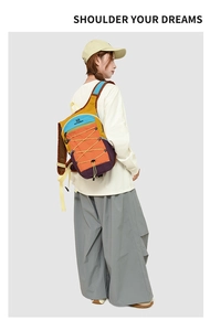 Detail view of colorful crossbody bag with bungee cords and wide strap shown on model